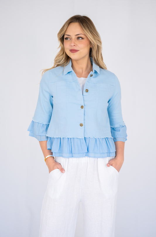 Woman wearing a blue Frill Denim Jacket over a white outfit on a white background