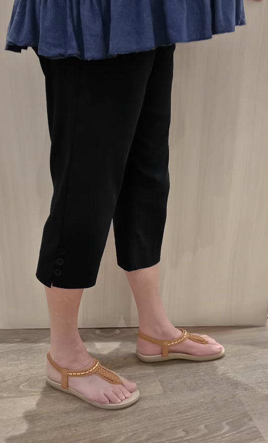 Woman wearing black SSF Button Pants with navy top and brown thongs near Boo Boo's counter