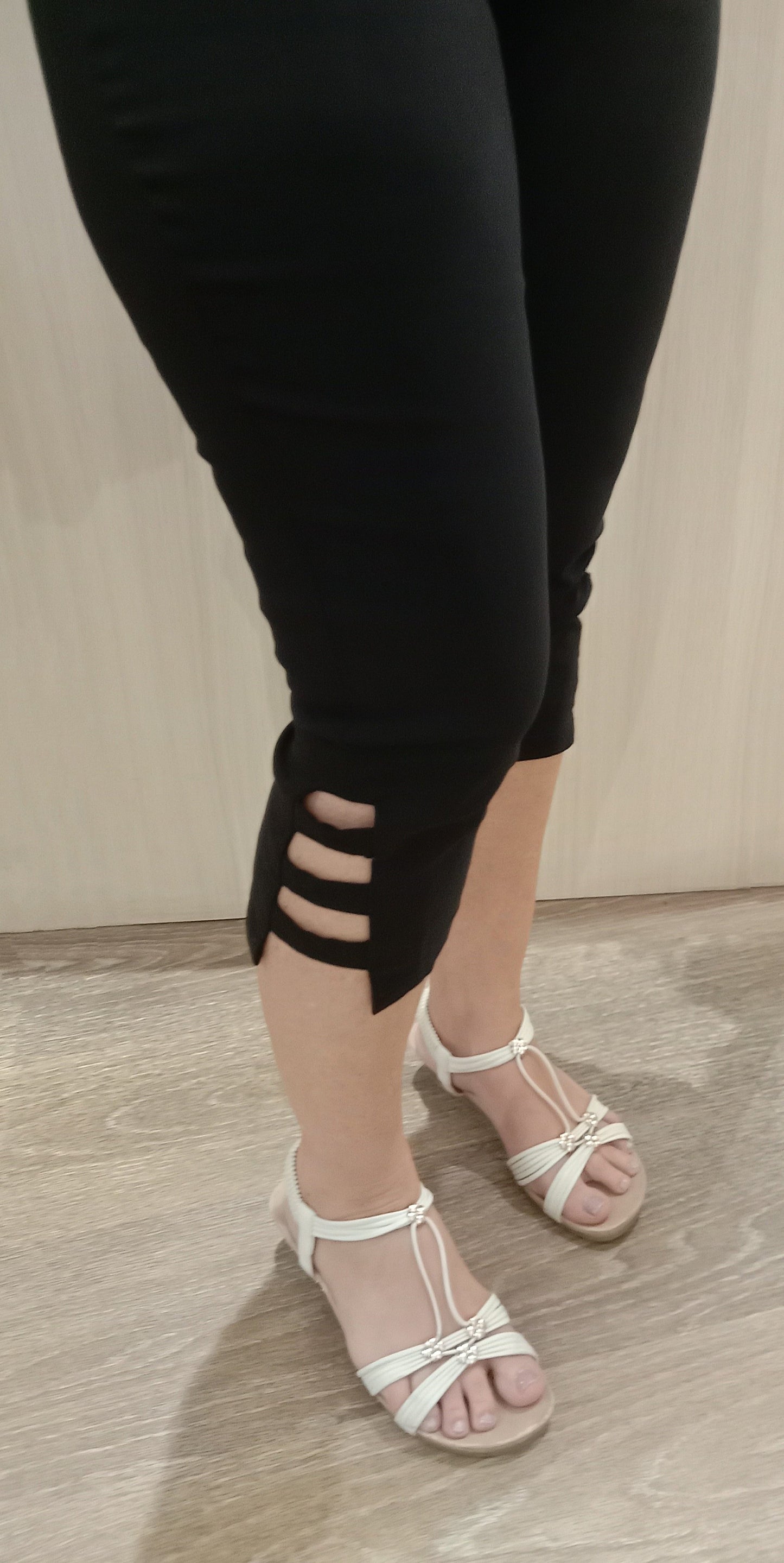 Woman wearing black SSF Stripe Pants with white sandals near Boo Boo's counter