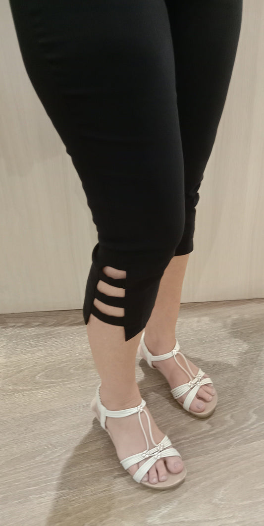 Woman wearing black SSF Stripe Pants with white sandals near Boo Boo's counter