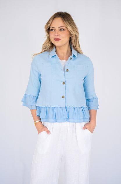 Woman wearing a blue Frill Denim Jacket over a white outfit on a white background